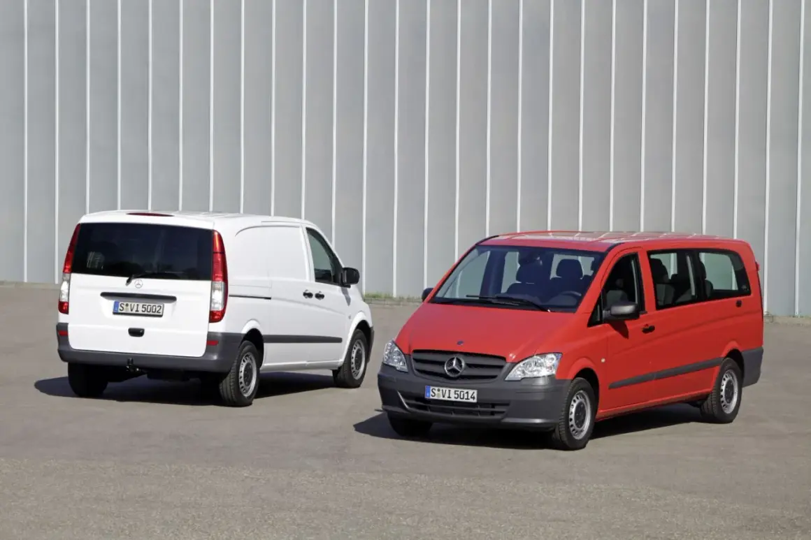 Dwa busy Mercedes-Benz: biały towarowy i czerwony osobowy, stojące na tle szarej ściany.